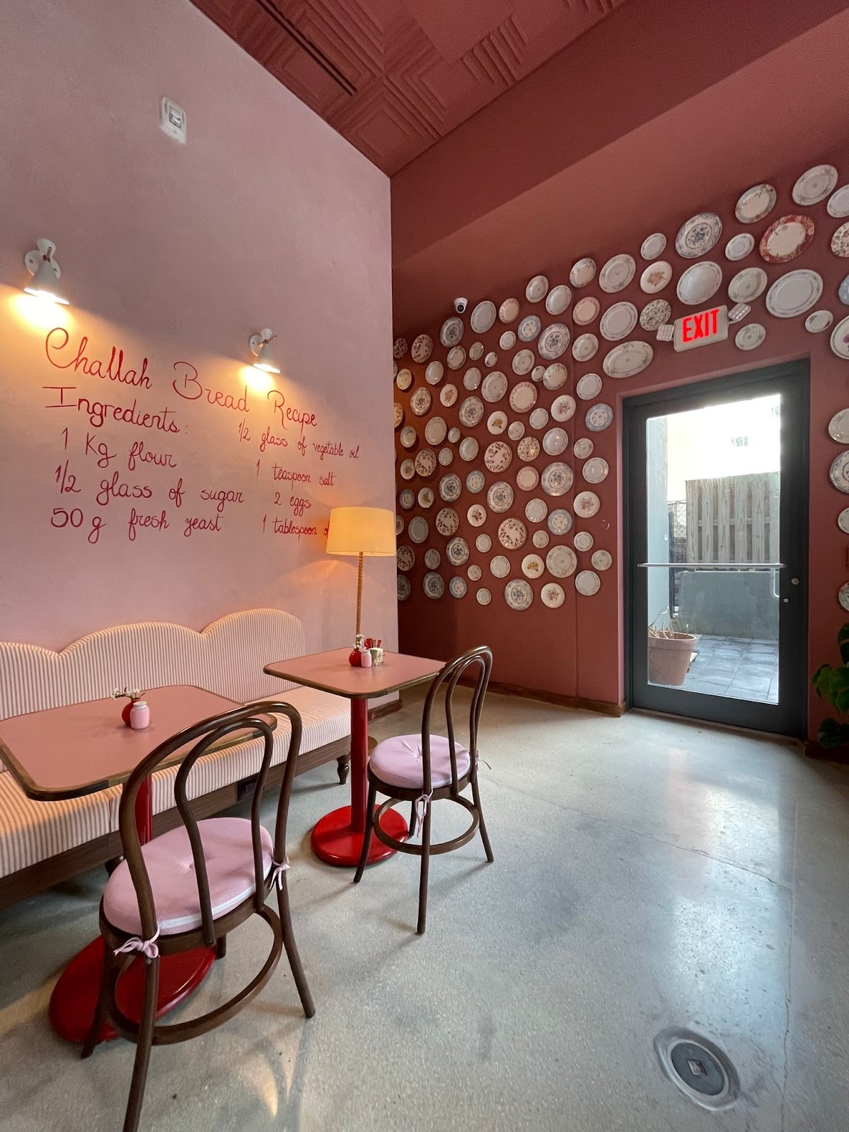 Bright modern bakery interior with sage-green tiles and a pastry counter