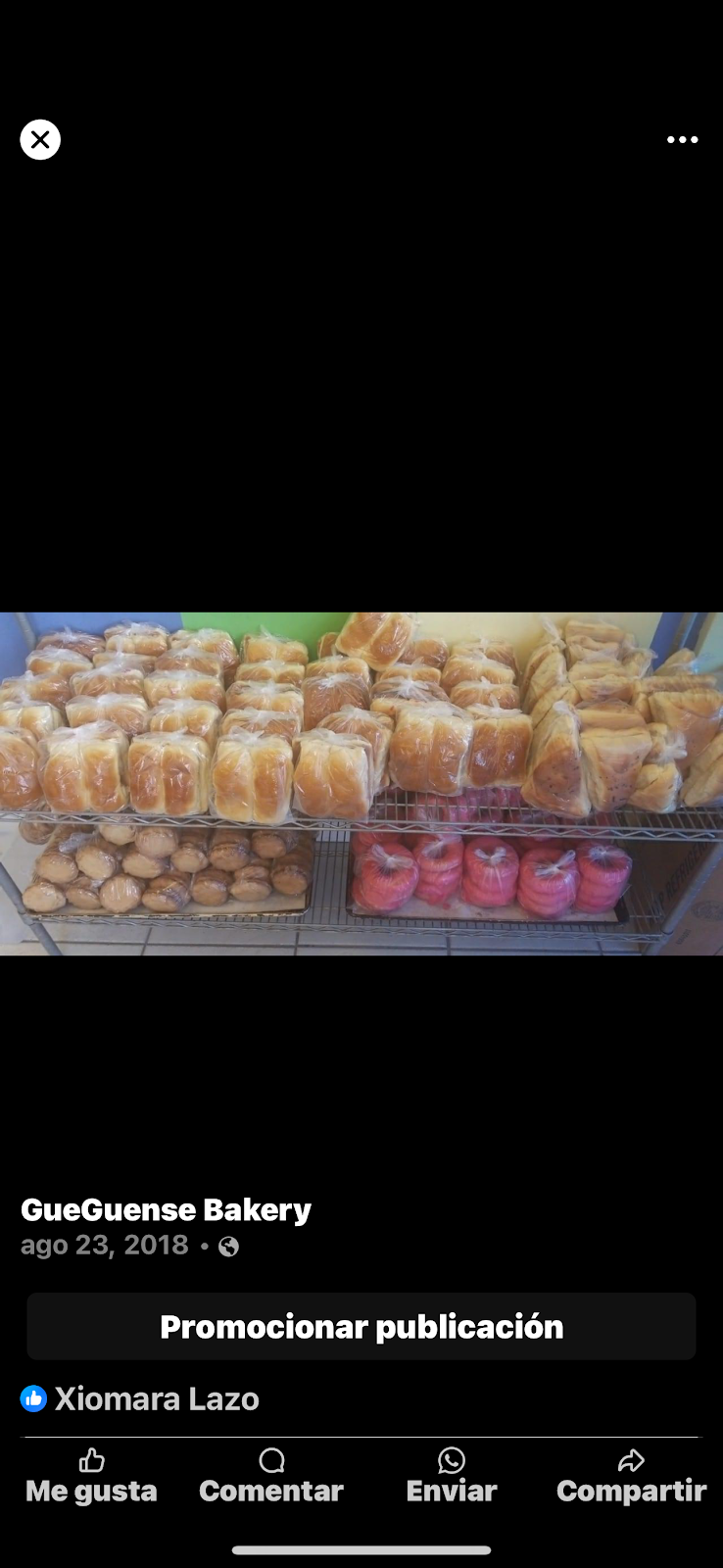 Two golden croissants on a dark plate beside a glass of milk