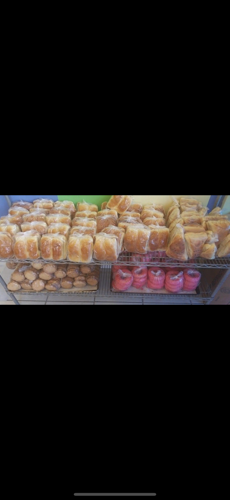 Warmly lit shelves stacked with rustic loaves and rolls