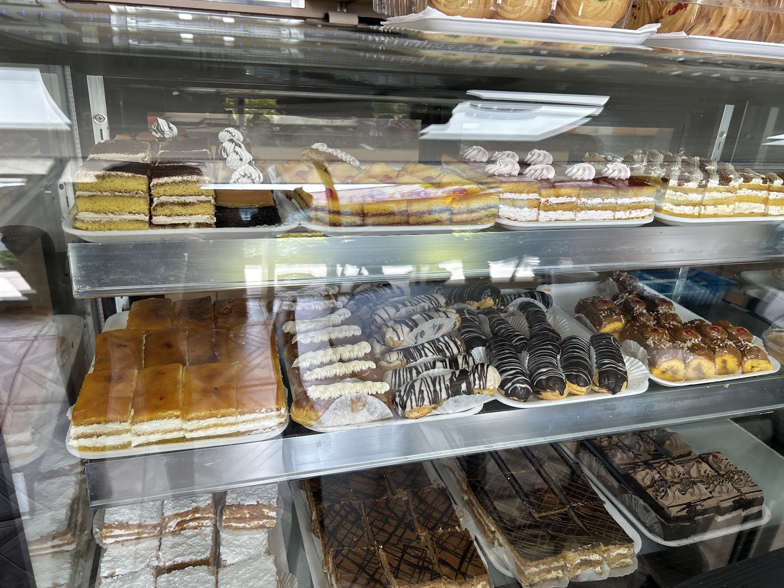 Bright modern bakery interior with sage-green tiles and a pastry counter