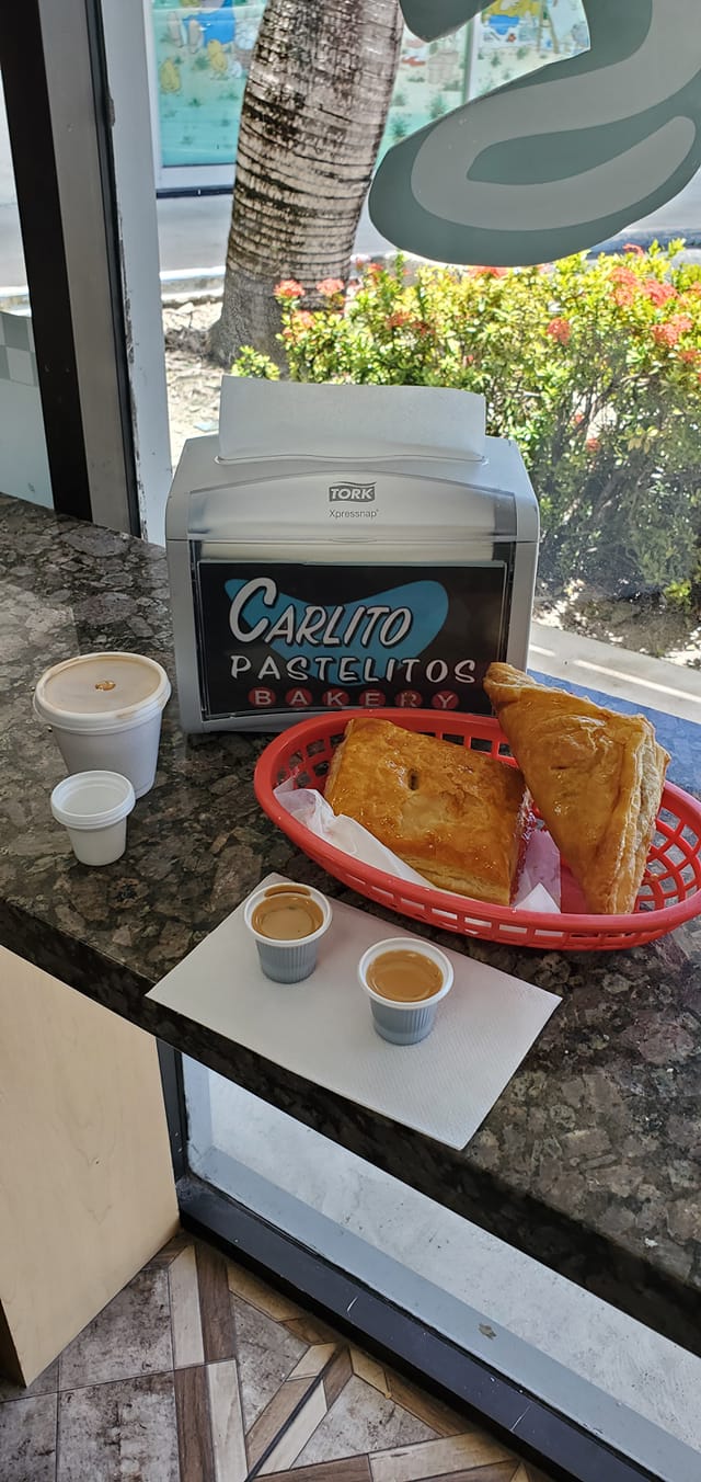 Two golden croissants on a dark plate beside a glass of milk