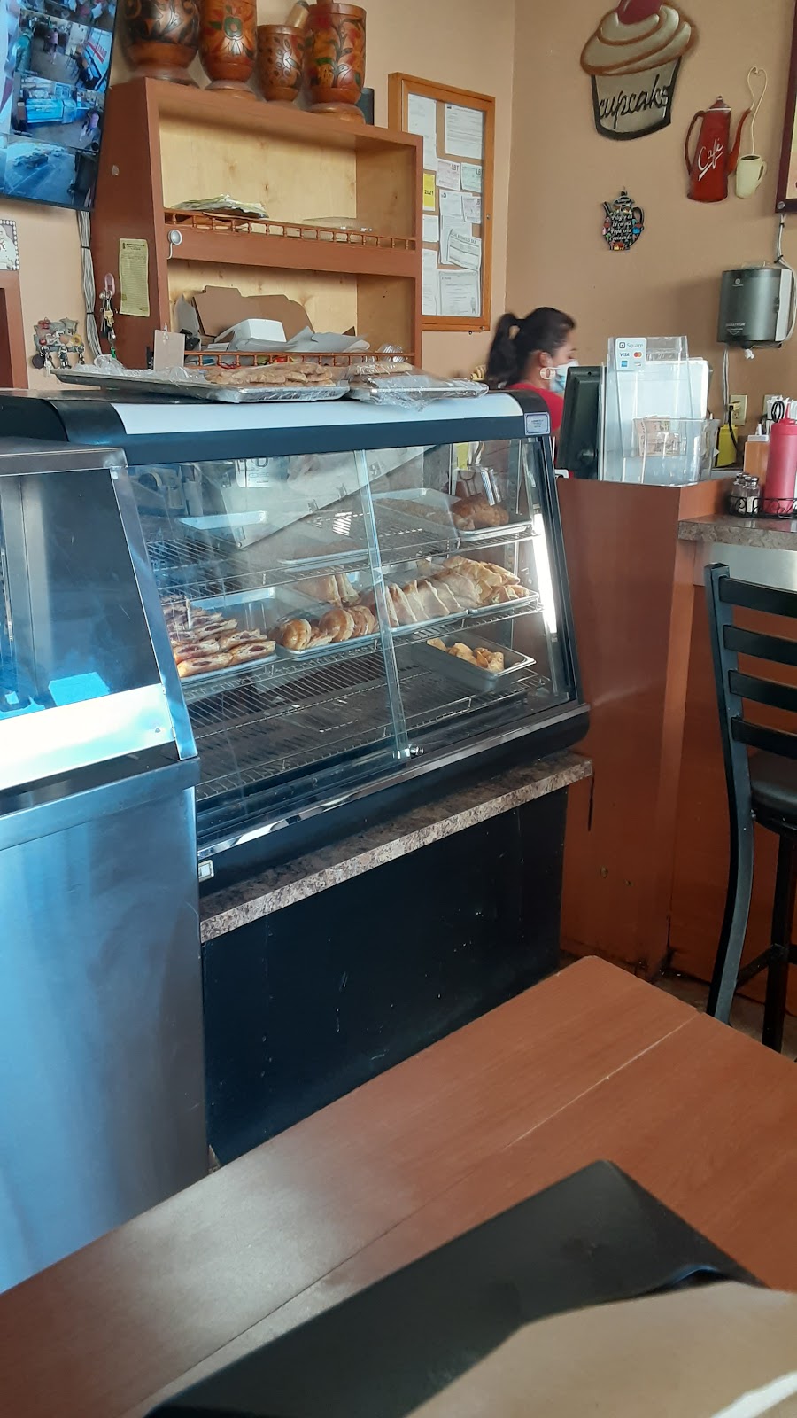 Bright modern bakery interior with sage-green tiles and a pastry counter