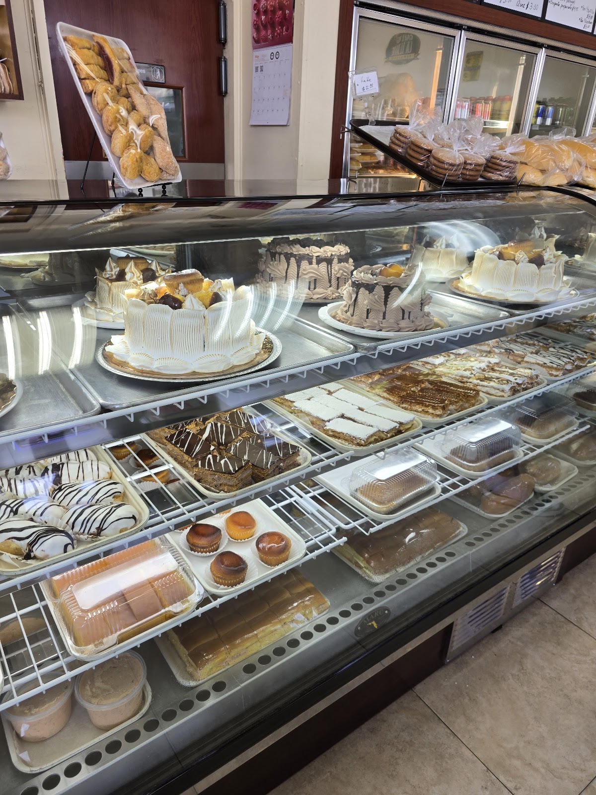 Bright modern bakery interior with sage-green tiles and a pastry counter