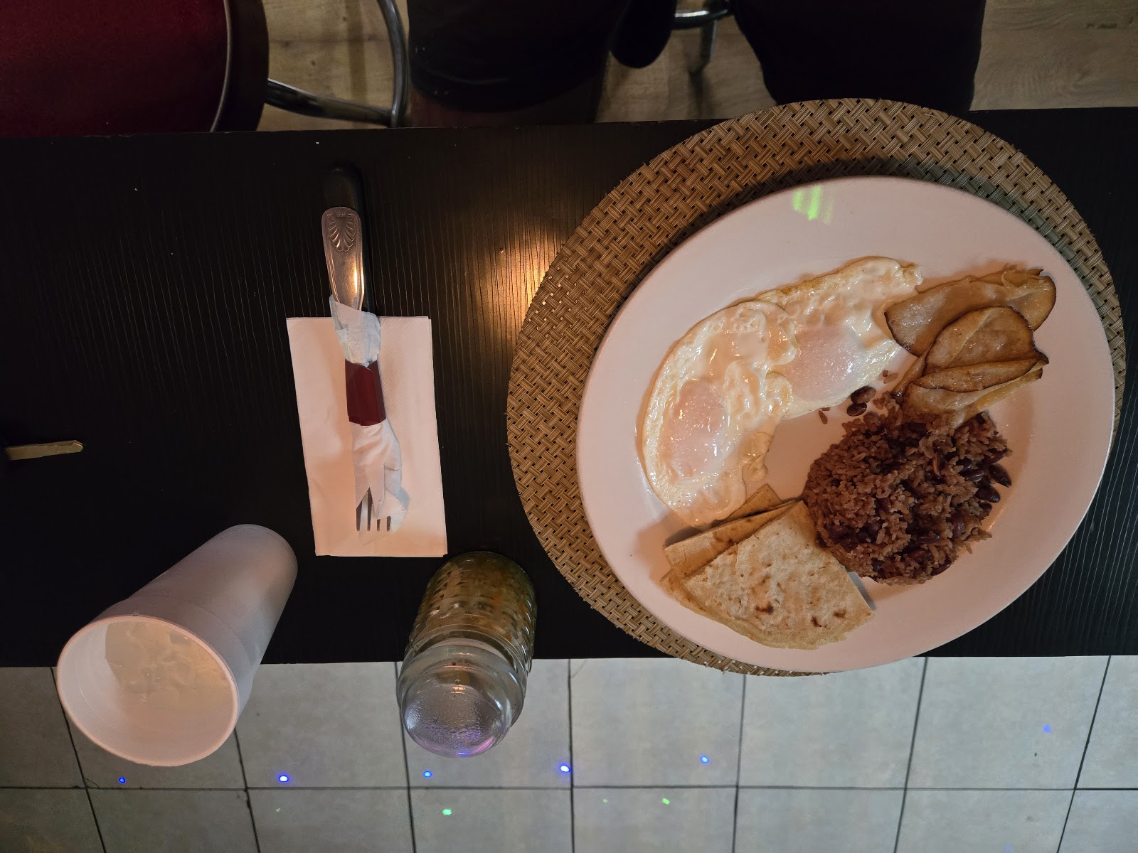 A chef finishing a plated fine dining dish under a single spotlight