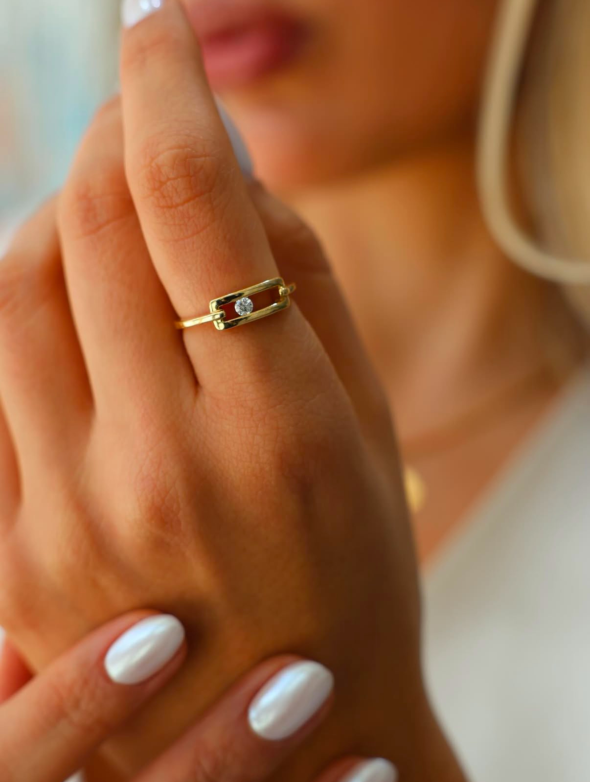 Model wearing a sculptural gold hoop earring