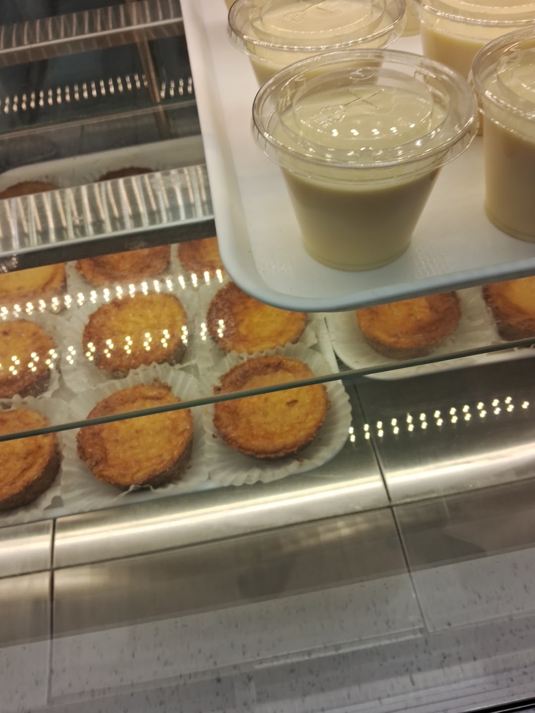 Bright modern bakery interior with sage-green tiles and a pastry counter
