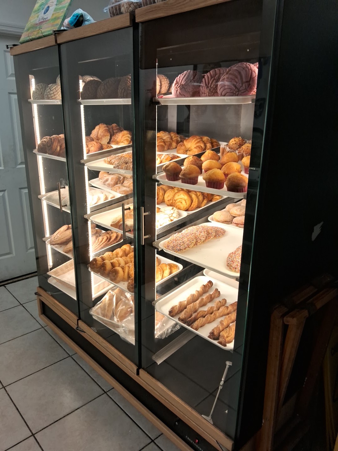 Warmly lit shelves stacked with rustic loaves and rolls