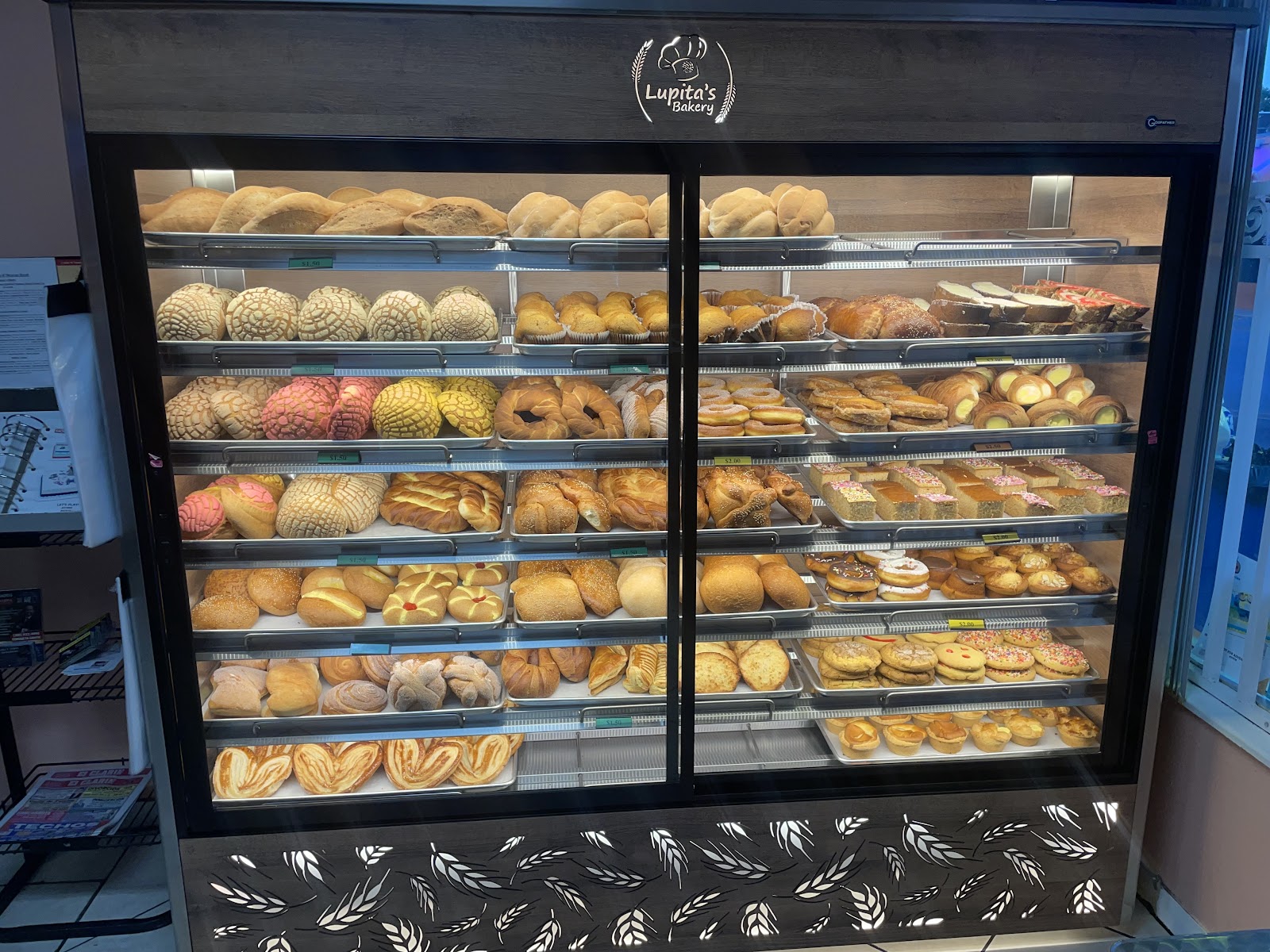 Warmly lit shelves stacked with rustic loaves and rolls