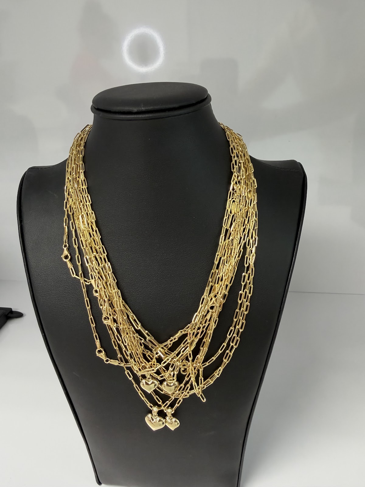 18k gold necklace displayed on a dark bust