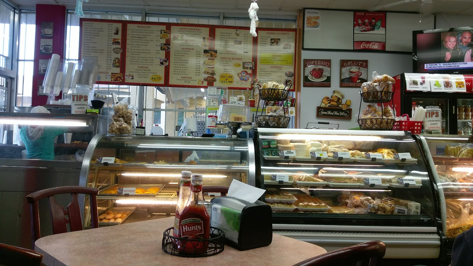 Bright modern bakery interior with sage-green tiles and a pastry counter