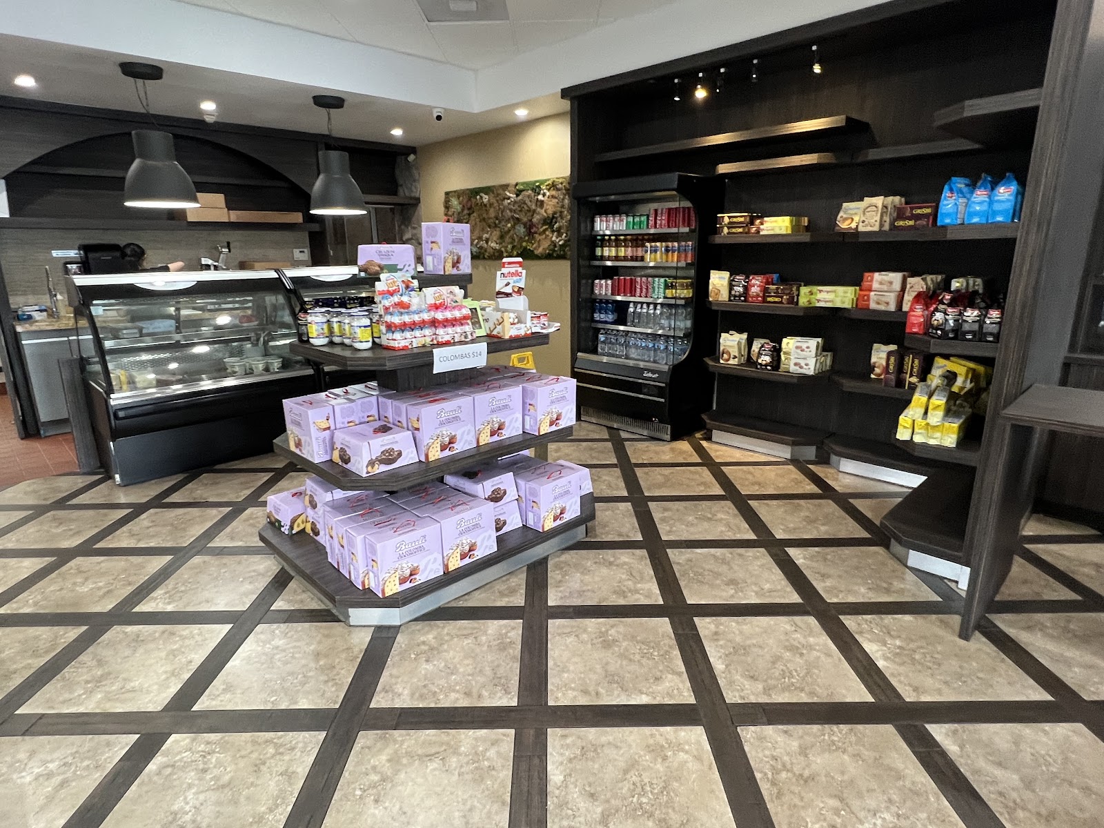 Bright modern bakery interior with sage-green tiles and a pastry counter