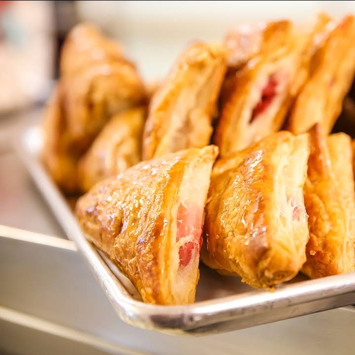 A glass display case full of fresh danishes and pastries